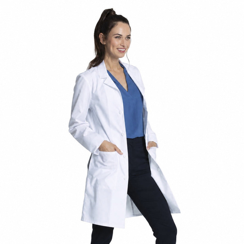 Bata médica Cherokee CK460 unisex color blanco, modelo mujer con manos en bolsillos